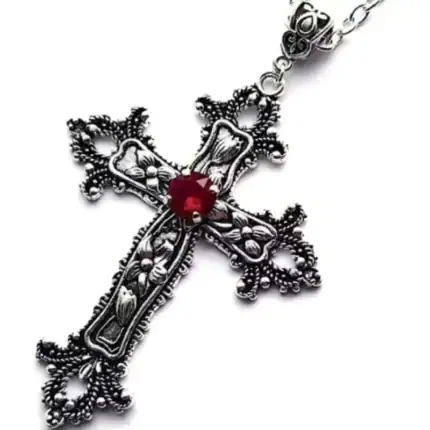 Croix catholique en argent avec rubis rouge au centre.