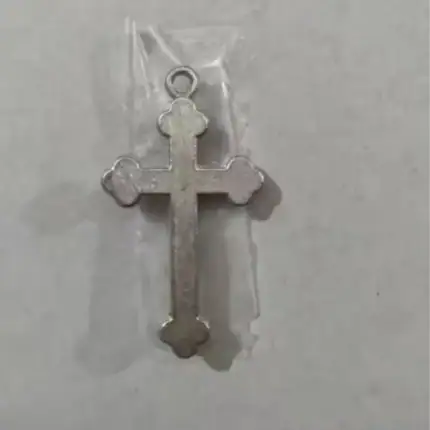 Croix chrétienne en métal rose, symbole religieux et de foi.