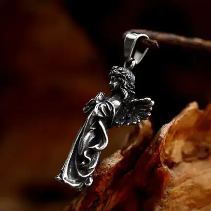 Pendentif ange en argent avec détails fins et ailes déployées.