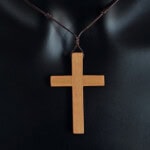 Croix en bois suspendue avec cordon pour prière ou décoration religieuse.